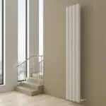 Modern white vertical radiator in a minimalist interior setting.