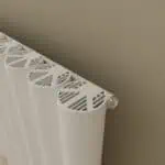 Radiator with stylish vented cover in a modern interior setting.