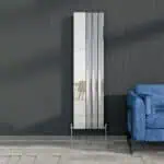 Modern vertical radiator in a contemporary living room with a blue sofa.