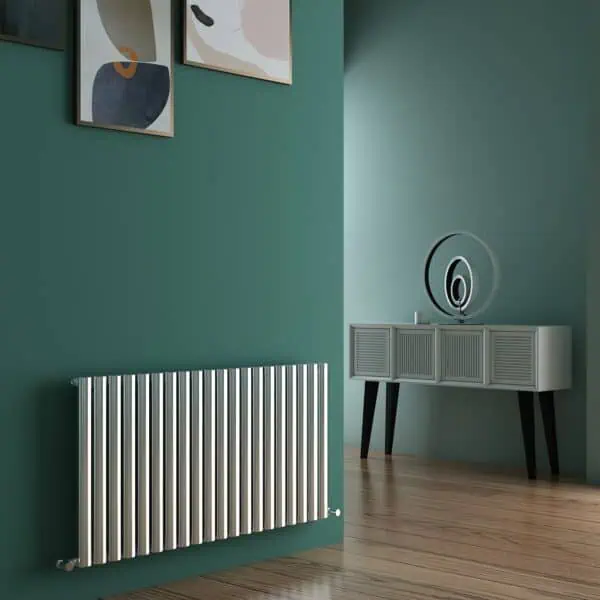 Radiator under a green wall with framed artwork, stylish modern interior decor, warm wooden flooring.