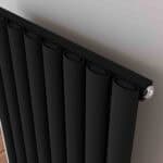 Black modern radiator with valve for heating systems.