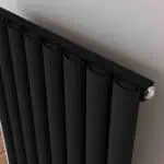 Black modern radiator with valve for heating systems.
