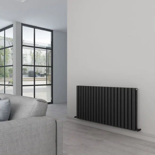 Modern black radiator installation inside a contemporary living room with large glass doors.