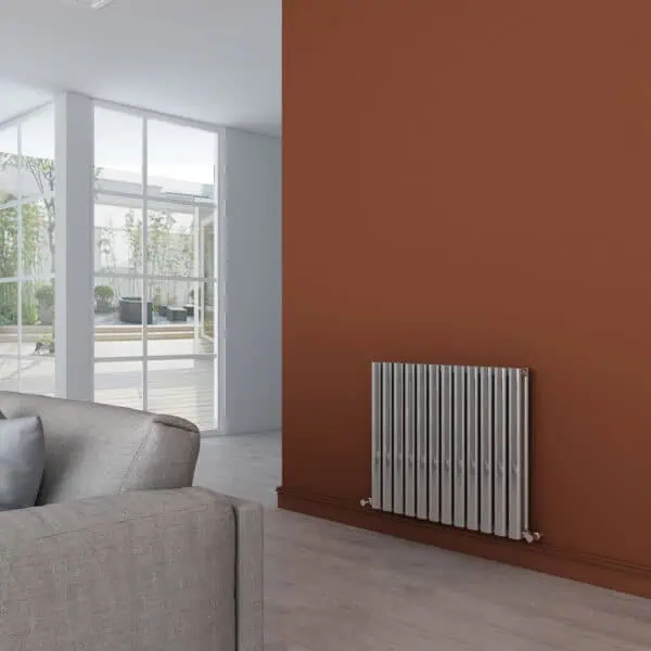 Modern living room with new radiator, brown accent wall, and large glass doors opening to outdoor garden.