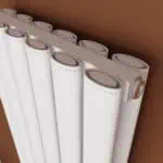 Radiator with multiple vertical white panels and thermostatic control, modern heating system.