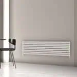 Contemporary white horizontal radiator mounted on a beige wall in modern interior design.