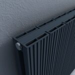 Modern black aluminum radiator with adjustable valves for efficient heating.