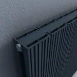 Modern black aluminum radiator with adjustable valves for efficient heating.