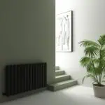 Radiator and staircase in minimal modern interior design, with potted plant and artwork.
