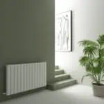 Modern interior with a white radiator, staircase, and green indoor plant in a contemporary home.