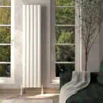 Radiator installation in a modern living room with large windows and natural light.
