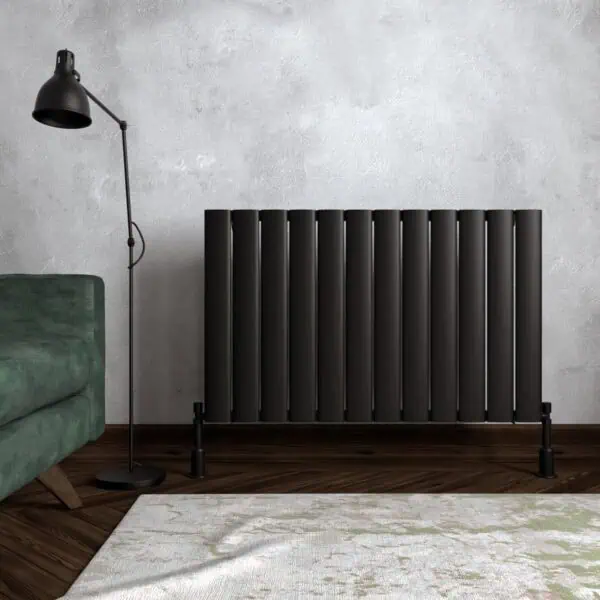 Stylish black radiator in modern home interior with green velvet sofa and floor lamp.