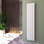 Modern vertical white radiator mounted on a green wall in contemporary interior.
