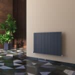 Modern black radiator on beige wall in stylish interior space.