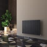 Sleek black modern radiator on a beige wall in stylish interior space.