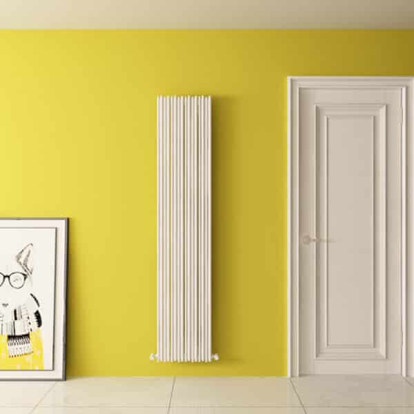 Radiator heating system on vibrant yellow wall in modern interior design.