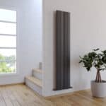 Modern black vertical radiator in a bright home interior.