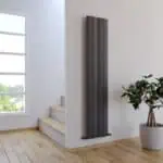 Modern black vertical radiator in a bright home interior.
