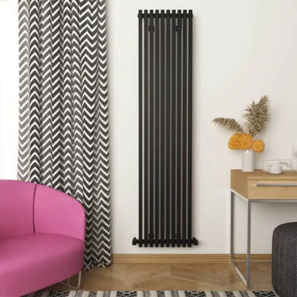 Stylish black vertical radiator in modern living room with patterned curtains and pink sofa.