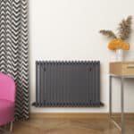 Radiator heating panel in modern interior living space with decorative vase and flowers.