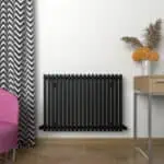 Radiator cover in modern home interior with stylish decor and a flower vase.