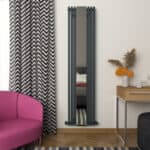 Modern vertical radiator with mirror in stylish interior decor setting.