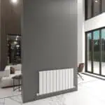Modern interior with a sleek white radiator on a gray wall in a bright living space.