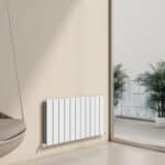 Contemporary white panel radiator installed in modern apartment with large window and city view, ideal for home heating.
