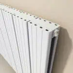 Modern white panel radiator with adjustable side valve for efficient home heating.