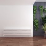 Modern interior with sleek white radiator and green plants, stylish home decor and wood flooring.