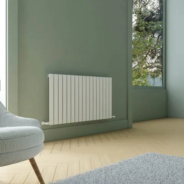 Radiator installation in modern green room with large window and wooden flooring.