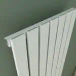 Quiet radiator in modern interior, heating system, home décor, grey wall background.