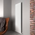 Modern white vertical radiator mounted on a gray wall in a contemporary interior.
