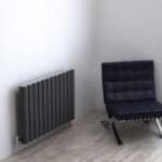 Radiator and modern black chair in minimalistic room, interior decor, contemporary furniture, cozy living space, Posh Rads benefits.