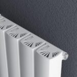 Modern white radiator with decorative vents in a contemporary indoor setting.