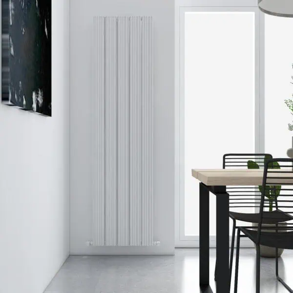 Modern vertical radiator in a minimalist dining room setting with black furniture and natural light.