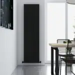 Vertical black radiator in modern interior, stylish home heating solution, slim designer radiator design, energy-efficient heating unit, modern decor element.