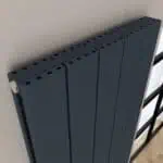 Modern black radiator with multiple panels for efficient heating and energy savings.