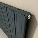 Heavy-duty modern radiator with adjustable valve, black aluminum design, heat distribution system, indoor heating solution.