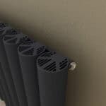 Black modern radiator with innovative ventilation design in a cozy home setting.