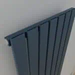 Modern black radiator for central heating in a home or office environment.