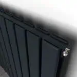 Radiator heating system, modern black panel radiator in close-up, home heating solution, energy-efficient heating technology, comfortable indoor climate.