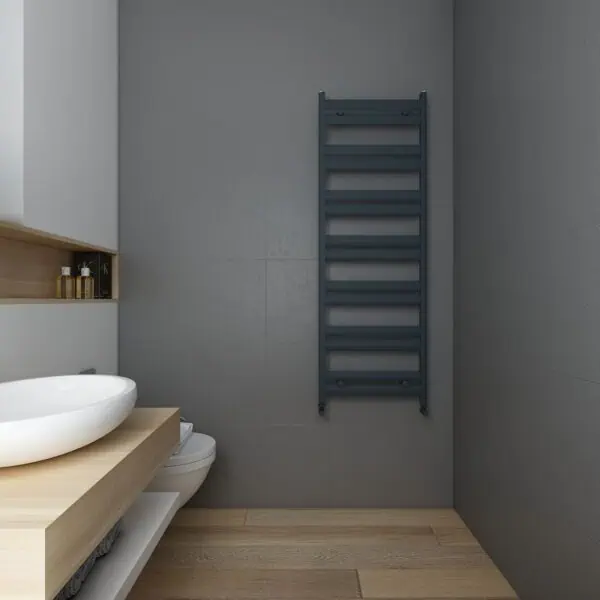 Modern grey heated towel rail in minimalist bathroom interior.