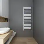 Modern white heated towel radiator in minimalist bathroom setting.
