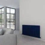 Modern residential interior with blue radiator and large glass doors, minimalistic decor, bright natural light, stylish home heating solution, contemporary design.