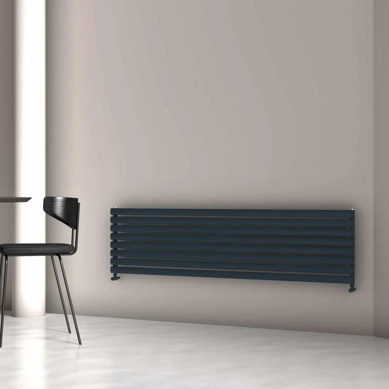 TALLIS XL 470X1800X8 TXA Modern black radiator wall heater in a minimalist interior with a black chair and gray wall.