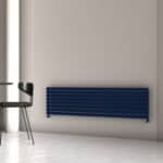 Contemporary navy blue radiator mounted on a neutral wall in a modern interior setting.