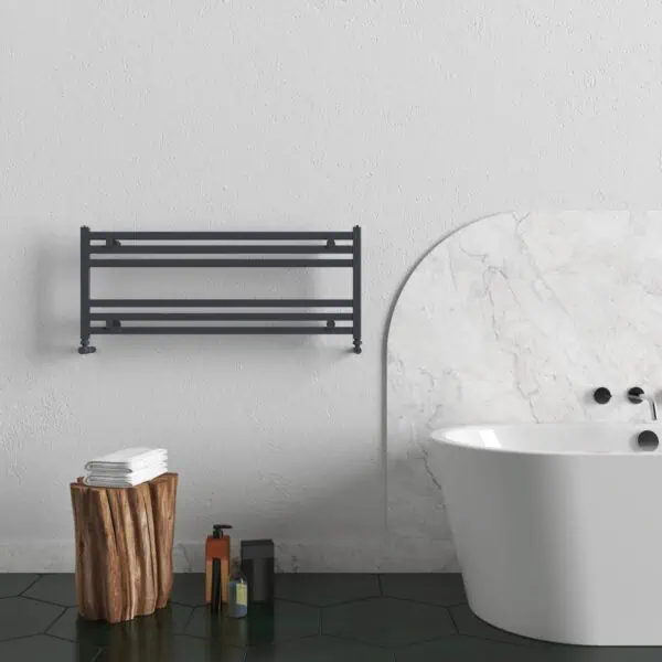 Black wall-mounted towel rack in modern bathroom with white bathtub and natural wood side table.