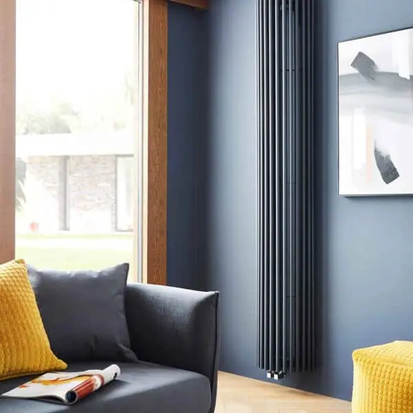 Modern black vertical radiator in contemporary living room with blue accent wall.