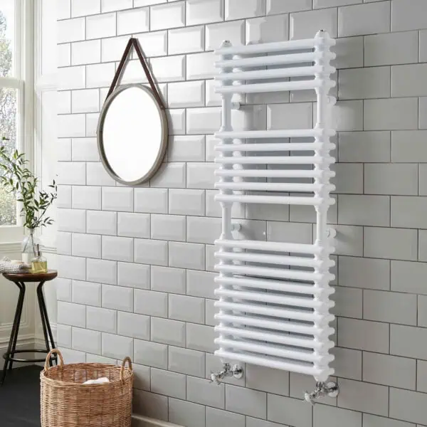 Radiator towel rail heater in contemporary bathroom with white tiles and natural decor.